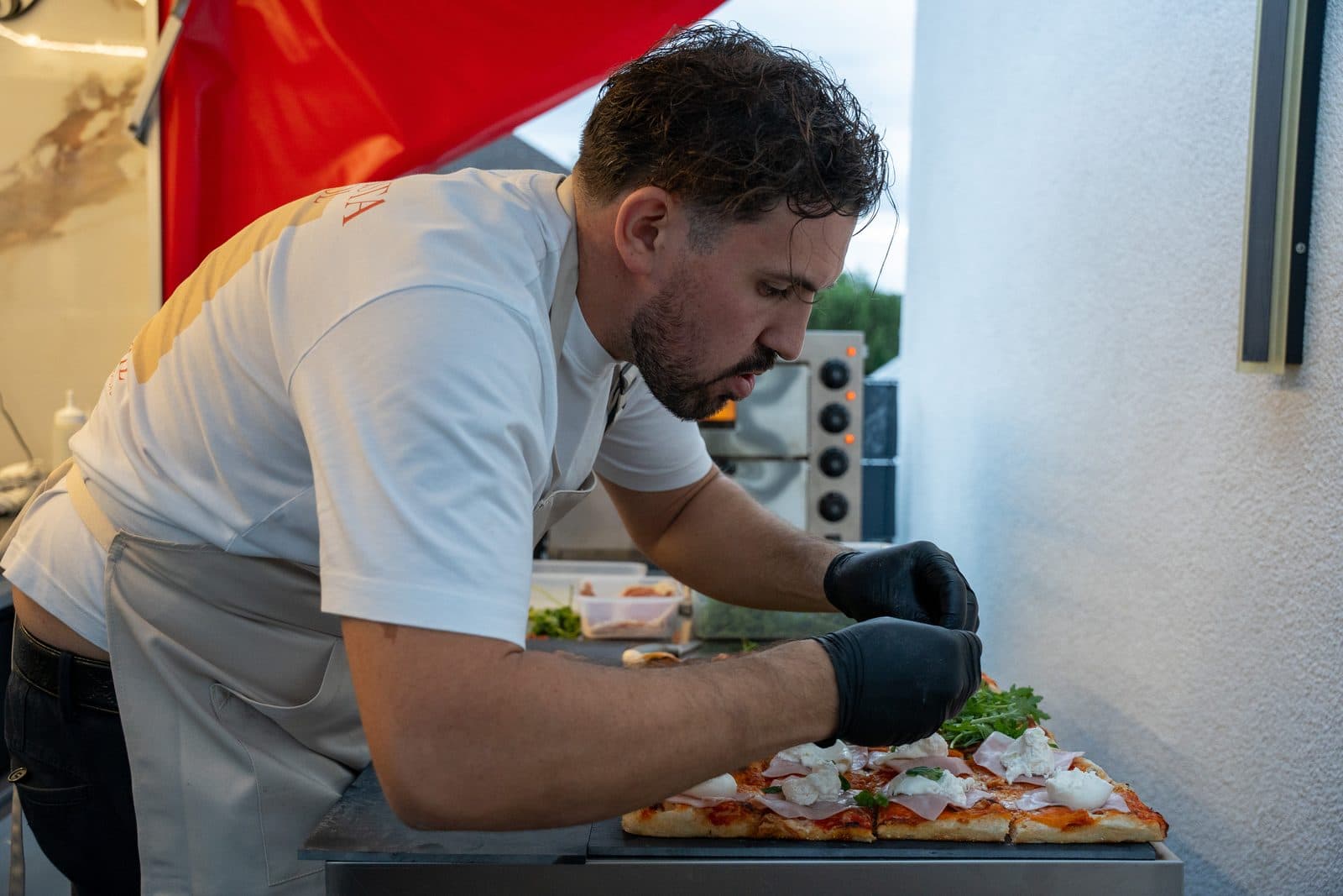 Graziano belegt die Pizza frisch in der Ape