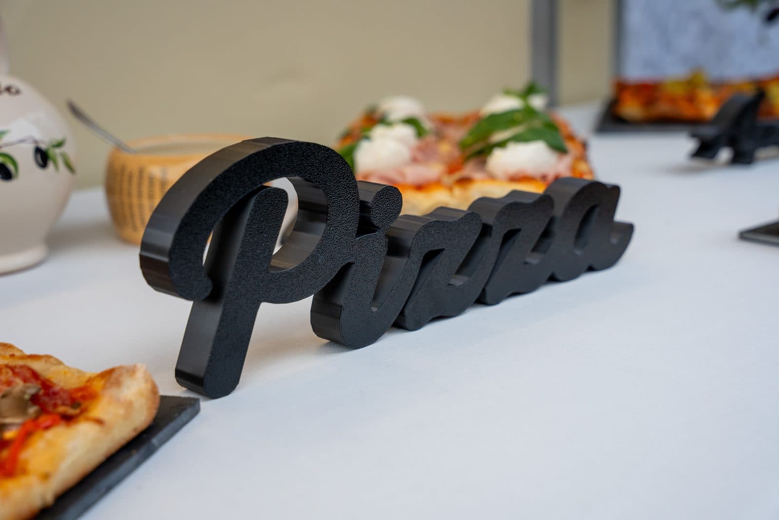 Pizza-Schriftzug und Pizza auf dem Buffet