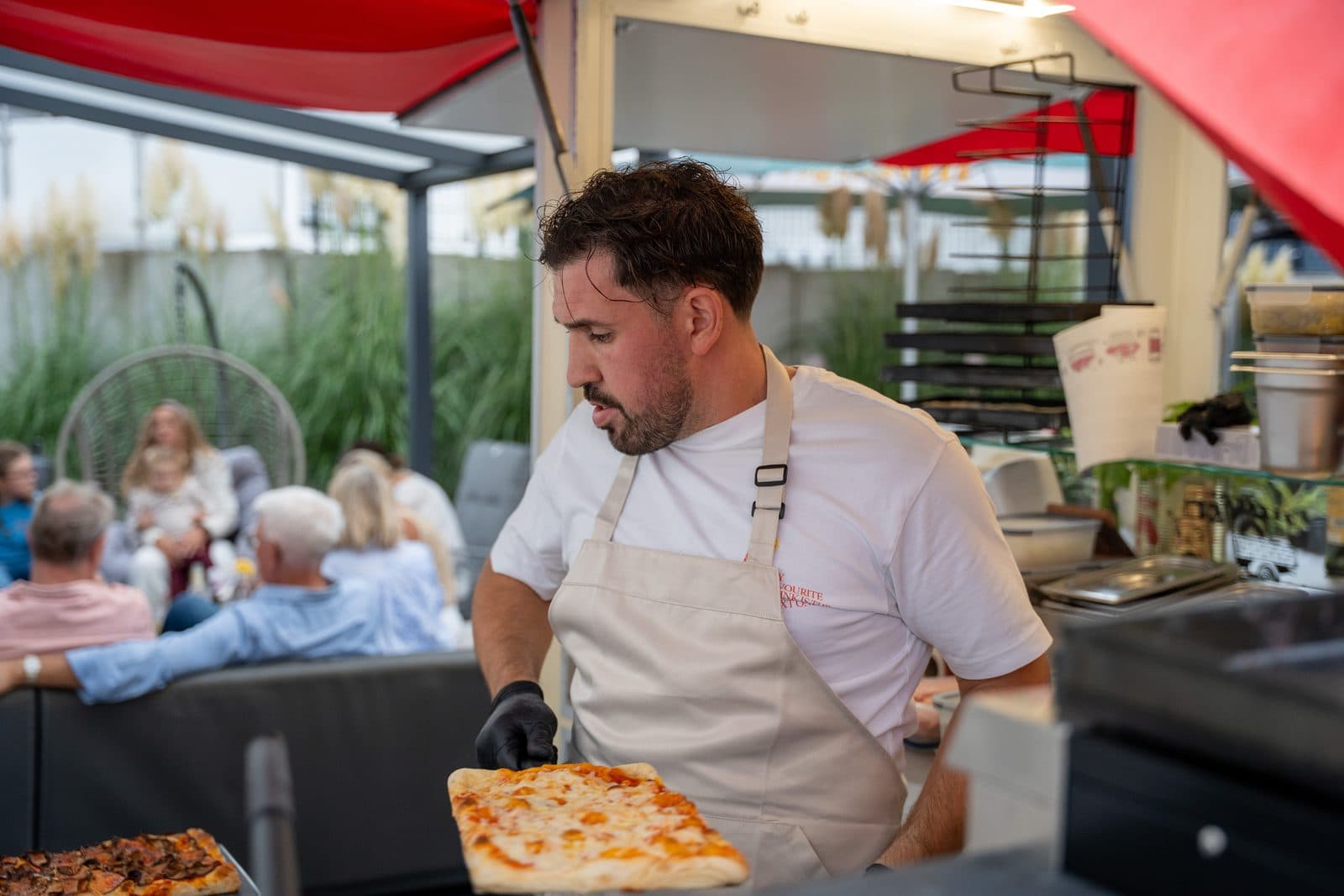 Graziano serviert frische Pizza an die Gäste